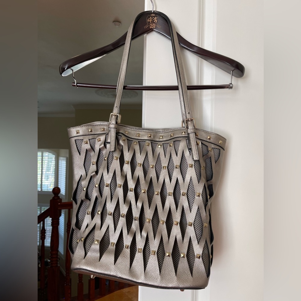 Eye catching silver leather tote bag with gold studs and cutouts. EUC